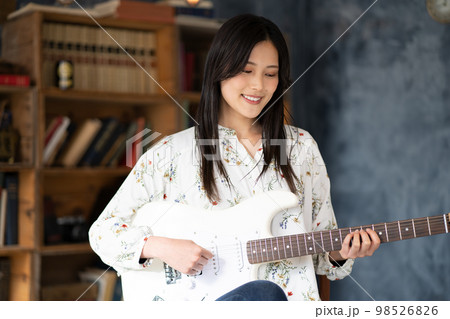 ギターを弾く若い女性 98526826
