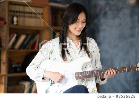 ギターを弾く若い女性 98526828