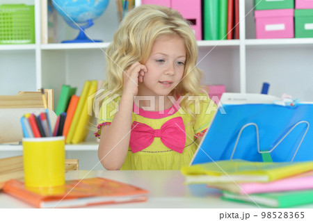 little girl studying at home at the table little girl studying at home at the table 98528365