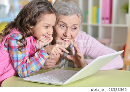 portrait of grandmother and granddaughter using modern laptop portrait of grandmother and granddaughter using modern laptop 98528366