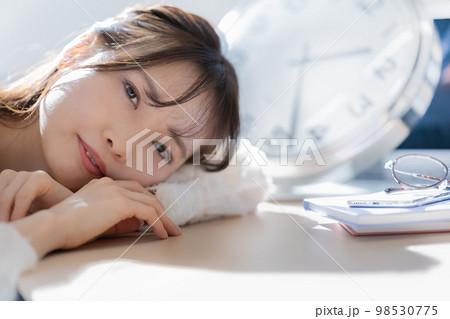 机に伏せる若い女性の顔のアップ イメージの写真素材 [98530775] - PIXTA