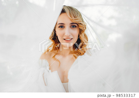 portrait under the veil. a beautiful blonde bride in a white dress. 98533317