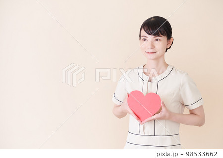 ハートマークをもつ黒板を持つエステ・美容クリニックの女性 98533662