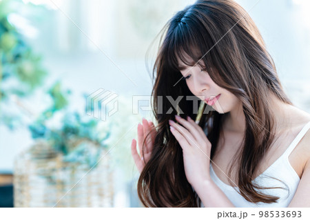 ヘアケアをする若い女性 ヘアケアをする若い女性 98533693
