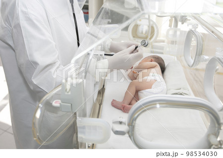 A newborn baby lies in boxes in the hospital. A child in an incubator. Neonatal and Premature Intensive Care Unit 98534030