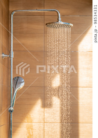Outdoor shower head for the bath and showering cold water to body before jumping in the resort pool. 98534331