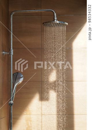 Outdoor shower head for the bath and showering cold water to body before jumping in the resort pool. 98534332