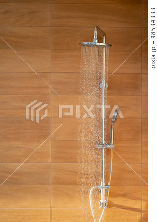 Outdoor shower head for the bath and showering cold water to body before jumping in the resort pool. 98534333