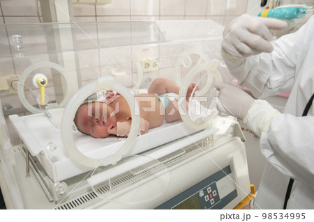 A premature newborn in a special incubator in the children's department of the hospital. A premature newborn in a special incubator in the children's department of the hospital. 98534995