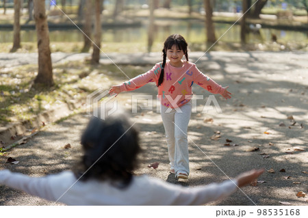 Asian Grandmother and Granddaughter hug together outdoor park. Hobbies and leisure, lifestyle, family life, happiness moment concept 98535168