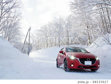 冬のドライブイメージ　雪景色の山道とコンパクトカー 98535627