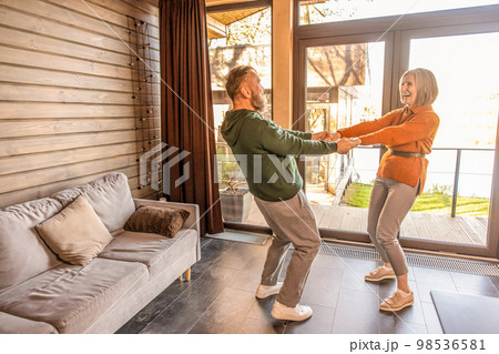 Happy couple dancing at home and looking energized and excited 98536581