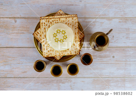 During Passover Jewish holiday celebration, matzoh is served as accompanied by kiddush four cups red kosher wine 98538602