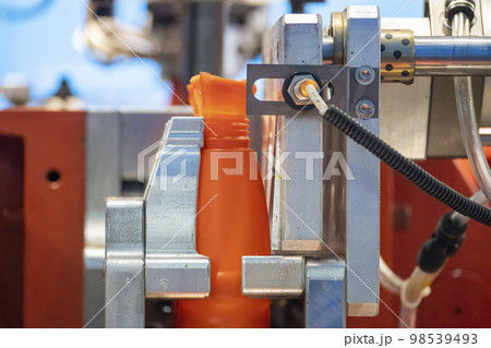 The orange bottle container manufacturing process by blow mold machine. 98539493