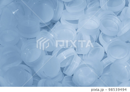 The pile of clear plastic bottle caps. 98539494