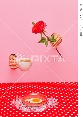 Food pop art photography. Female hand sticking out pink paper with coffee cup and rose flower. Fried eggs for breakfast 98539614