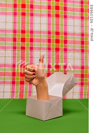 Pop art photography. Female hand sticking out food box and showing gesture of approvement over retro background Pop art photography. Female hand sticking out food box and showing gesture of approvement over retro background 98539668