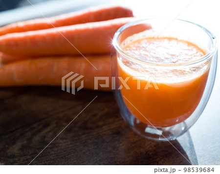 Organic carrot juice in glass on dark wooden background 98539684