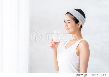 窓際で水を飲む女性。 窓際で水を飲む女性。 98540243