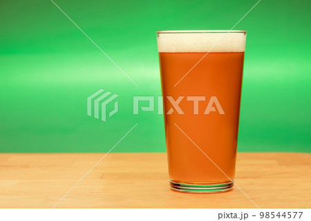 Full shaker pint glass of ale or beer on a table Full shaker pint glass of ale or beer on a table 98544577