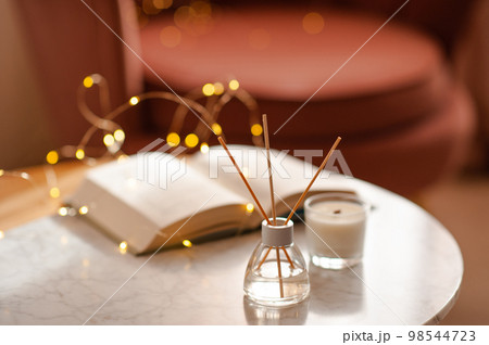 Home liquid fragrance with candles on table in room 98544723