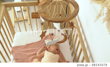 Baby girl crying while lying in the crib, selective focus. View from above Baby girl crying while lying in the crib, selective focus. View from above 98545079