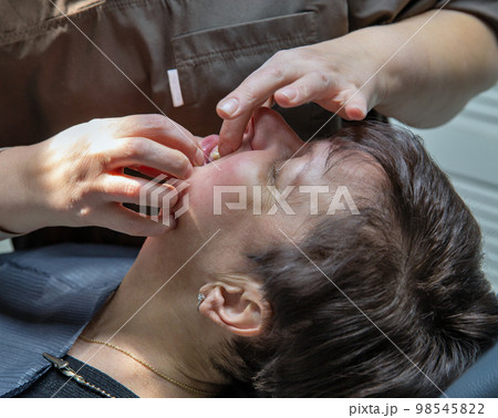Dentist working with a patient in a dental office. Dentist working with a patient in a dental office. 98545822
