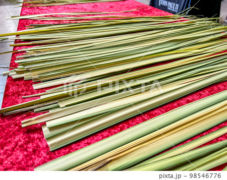 Palm frond leaves laid out on a table during Christian Sunday service. 98546776