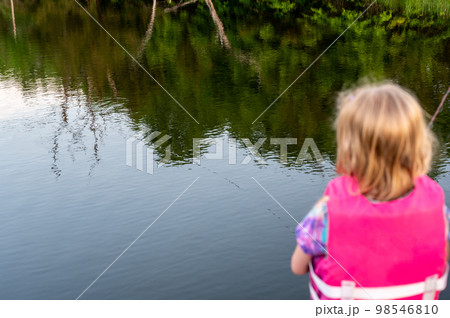 girl fishing with blue water in background girl fishing with blue water in background 98546810