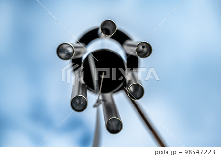 Looking up to the sky underneath a spinning wind chime. 98547223