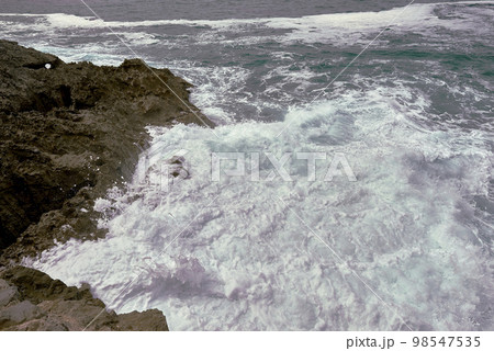 Waves breaking on the rocks at the shore of the beach Waves breaking on the rocks at the shore of the beach 98547535