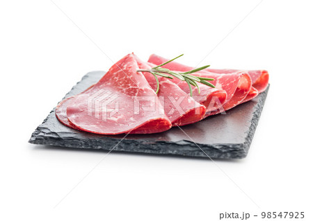 Smoked bresaola. Italian appetizer. Dried beef meat isolated on white backgorund. Smoked bresaola. Italian appetizer. Dried beef meat isolated on white backgorund. 98547925