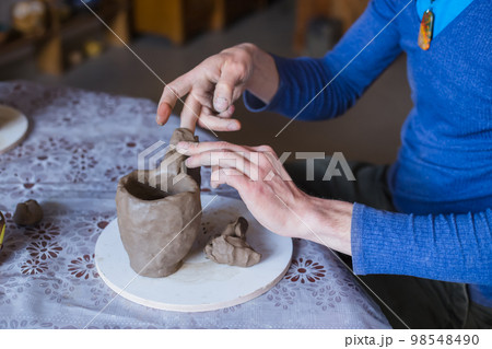 Close up view - professional male potter working in workshop, studio 98548490