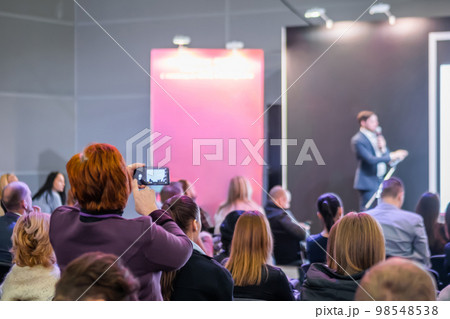 Back view of audience listening presentation at conference hall 98548538