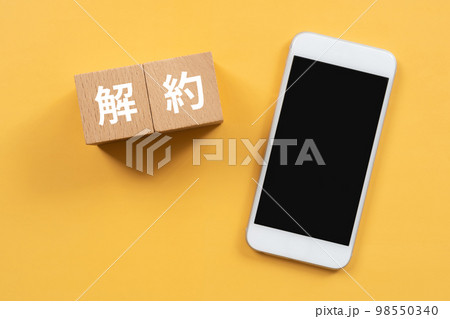 解約と書かれたブロックとスマホ 98550340