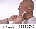 介護で老人の髭を剃る 98550743