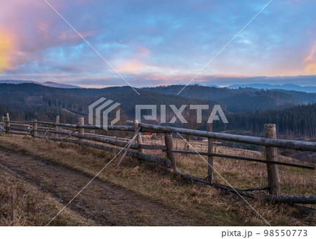 Picturesque pre sunrise morning above late autumn mountain countryside. Ukraine, Carpathian Mountains, Petros top in far. Peaceful traveling, seasonal, nature and countryside beauty concept scene. 98550773
