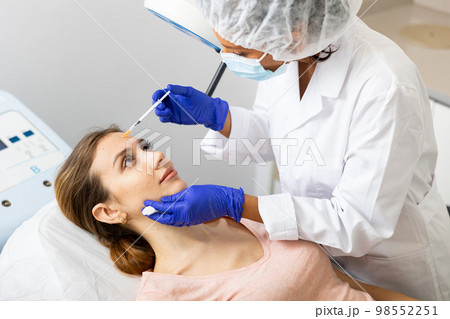 Beautician performing face contouring injections to woman Beautician performing face contouring injections to woman 98552251