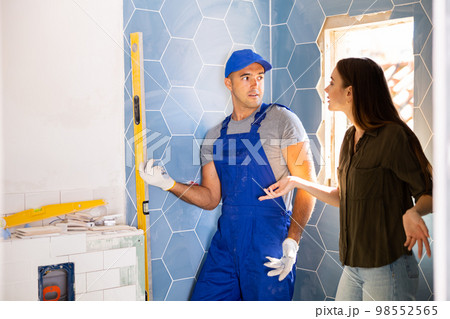 Woman dissatisfied with work done by the builder to renovate bathroom Woman dissatisfied with work done by the builder to renovate bathroom 98552565