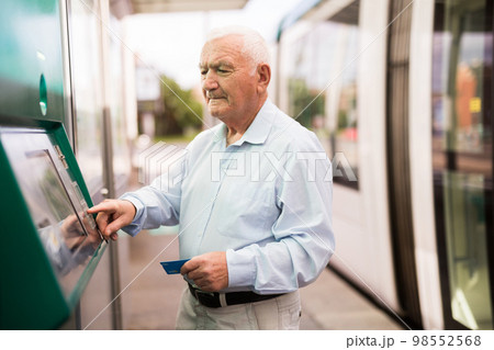 Elderly man using cash machine Elderly man using cash machine 98552568