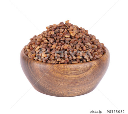 Buckwheat tea in wooden bowl, isolated on white background. Whole roasted buckwheat grains. Fagopyrum tataricum. Buckwheat tea in wooden bowl, isolated on white background. Whole roasted buckwheat grains. Fagopyrum tataricum. 98553082