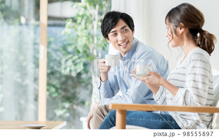 リビングで寛ぐ若い夫婦 98555897
