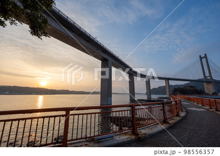 青空と夕日を浴びる加部島に架かる呼子大橋｜佐賀県唐津市 98556357