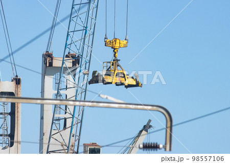 Industrial crane transfers cargo from one place to another Industrial crane transfers cargo from one place to another 98557106