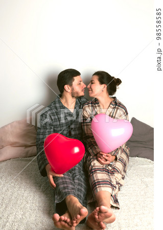 Couple of lovers holds balloons in the shape of a heart. The concept of Valentine's Day. Front view. 98558585