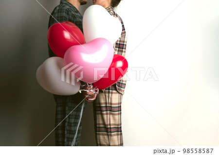 Couple of lovers holds balloons in the shape of a heart. The concept of Valentine's Day. Front view. 98558587