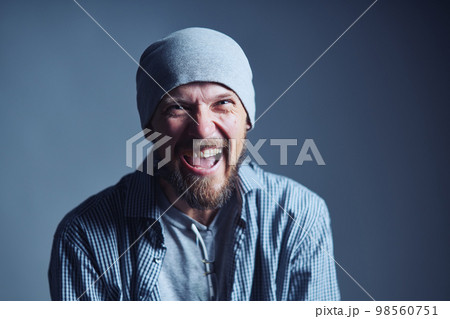 Mature 30s man in beanie hat crazy laughing at camera Mature 30s man in beanie hat crazy laughing at camera 98560751