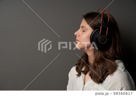 Closeup profile portrait of calm natural girl wearing headphones 98560817