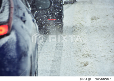 雪道を走る車のタイヤ 98560967
