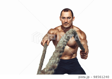 Strong young muscular man with naked torso doing exercises with rope isolated on white background 98561240
